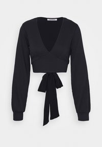 Must have musternakkade mustri ribidega lühike topp, millel on pikad varrukad, sügav V-kaelus ja nööri detail vööl. Omab tekstuurset kangast, mis lisab mõõtmeid.