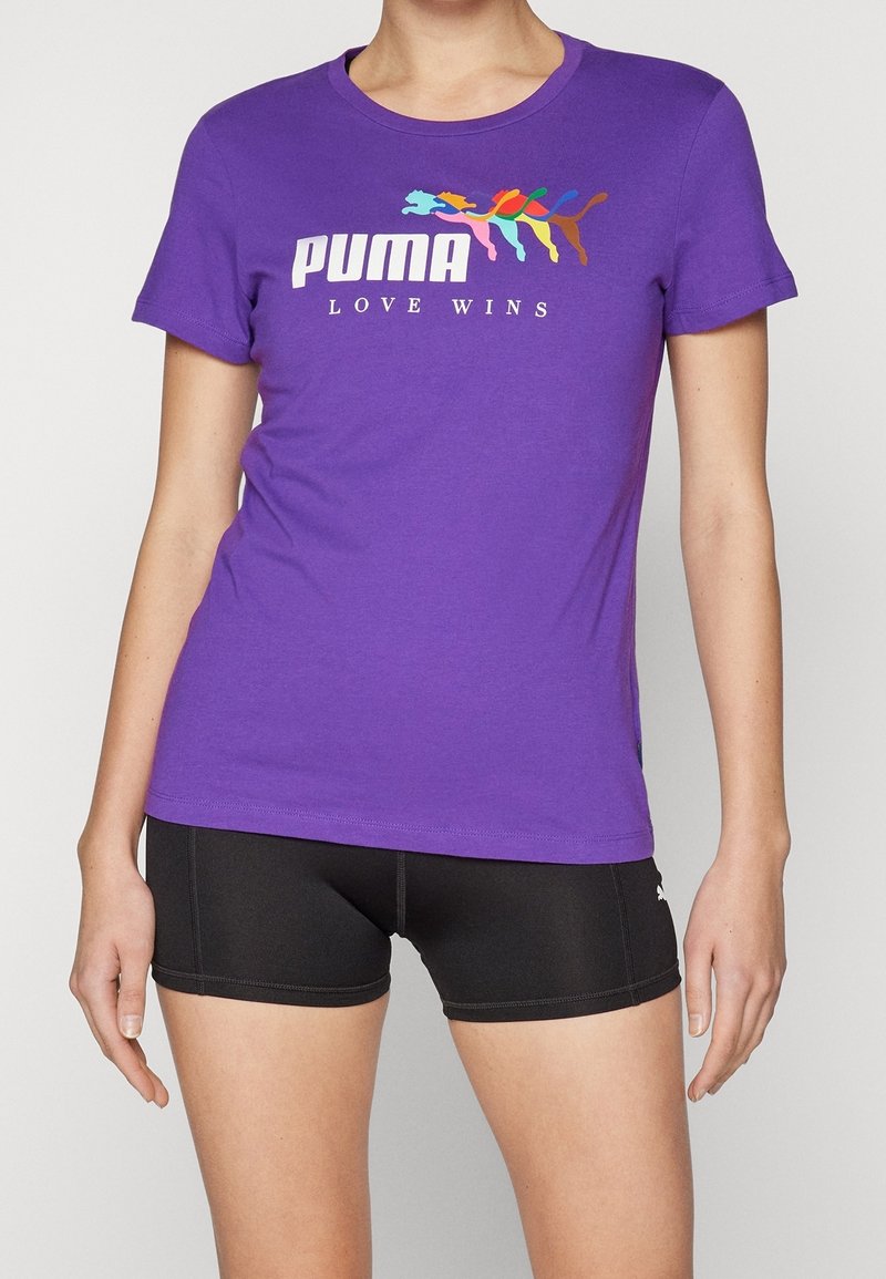 T-shirt en coton violet à manches courtes avec un graphisme multicolore d'animaux et le texte "PUMA LOVE WINS" en blanc.