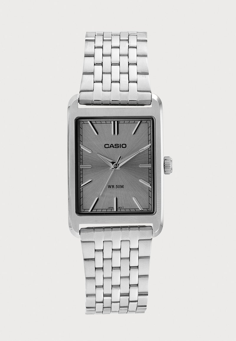 Montre Casio argentée avec cadran rectangulaire, bracelet métallique à maillons, index horaires minimalistes et résistance à l'eau jusqu'à 50 mètres.
