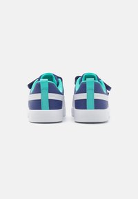 Baskets bleu et turquoise avec semelles blanches, en matériau lisse, dotées d'un col rembourré et d'un onglet de talon contrastant. Design simple sans motifs.