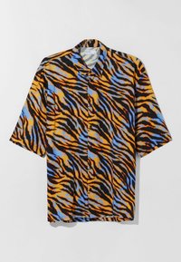 Koszula z krótkim rękawem z lekkiego materiału, ozdobiona wzorem w paski tygrysa w kolorach pomarańczowym, czarnym i niebieskim. Charakterystyczna dzięki kołnierzykowi typu spread i zapięciu na guziki z przodu.