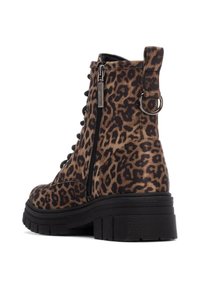 Botas de tobillo con estampado de leopardo, suela negra gruesa, cremallera lateral y diseño de cordones. Cuenta con un tirador en el talón para facilitar su uso.
