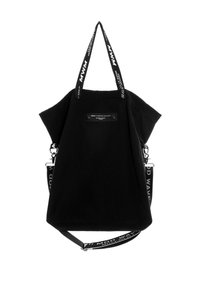 Bolso negro con correas de texto en contraste, forma estructurada y un parche con el logo en el frente. El material parece duradero con una textura mate.