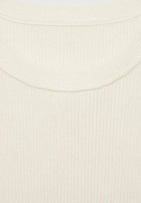 Pull crème en maille côtelée avec un col rond et un tissu texturé. Surface lisse avec de subtils traits verticaux sur toute la surface.