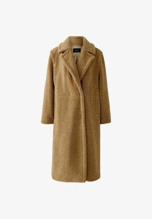 Manteau teddy long, en brun, avec des revers larges, deux poches latérales et un tissu en polaire doux et texturé.