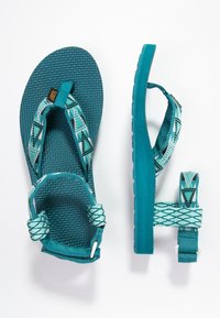 Sandali turchesi con cinturini decorati, suola testurizzata e cinturino regolabile sul tallone, mostrati in vista dall'alto e di lato su uno sfondo bianco.