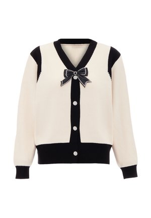 Cremfarbener und schwarzer gerippter Cardigan mit V-Ausschnitt, perlenähnlichen Knöpfen und einem schwarzen Schleifenakzent am Kragen. Weiche Textur mit kontrastierenden Farben.