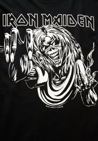 Juodas marškinėliai su baltu piešiniu, vaizduojančiu skeletinę figūrą su ilgais plaukais ir nagais, laikančia degantį objektą, o viršuje yra tekstas "IRON MAIDEN".