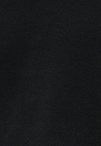 Tissu en velours noir avec une texture douce et lisse, montrant de subtiles réflexions de lumière sur sa surface.
