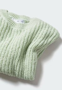 Pull en maille vert clair avec côtes texturées, encolure arrondie et manches repliées, affichant une apparence douce et confortable.