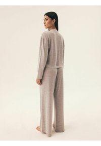 Szary zestaw dresowy z dzianiny, charakteryzujący się luźnym krojem, długimi rękawami i spodniami o szerokich nogawkach, z delikatnym wzorem teksturowym.