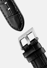 Zwarte leren horlogeband met een gestructureerde afwerking, voorzien van contrasterende stiksels en een zilveren metalen gesp met gegraveerd logo.