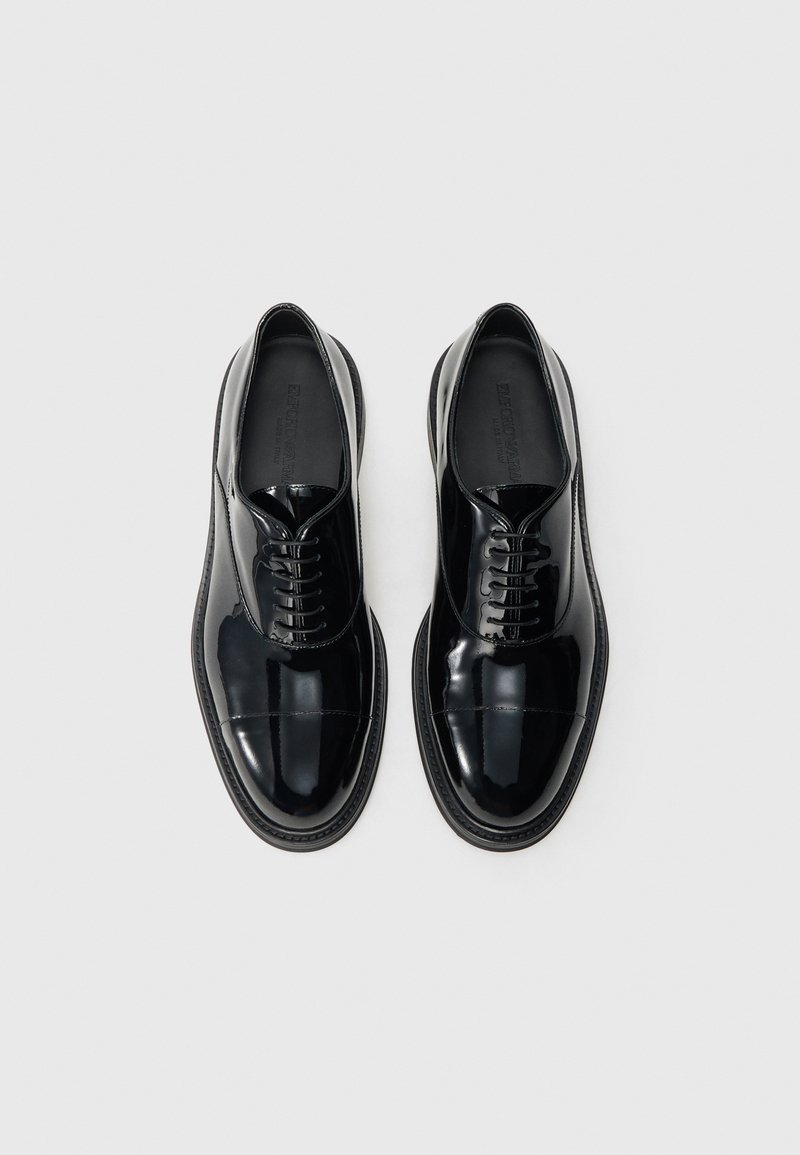 Chaussures à lacets en cuir noir brillant avec une finition lisse, bout arrondi et semelle contrastante. Présentent des coutures discrètes et des lacets texturés.