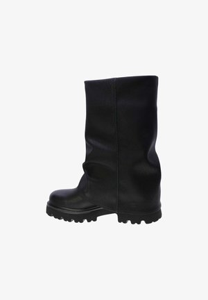 Botte mi-mollet en cuir noir avec une finition texturée, semelle épaisse et un design ample avec des détails de coutures visibles.