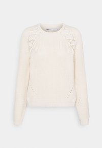 Kremowy sweter z dzianiny z rękawami raglanowymi, ozdobiony koronkowymi detalami na ramionach oraz teksturowanym wzorem ściegu na całej powierzchni.