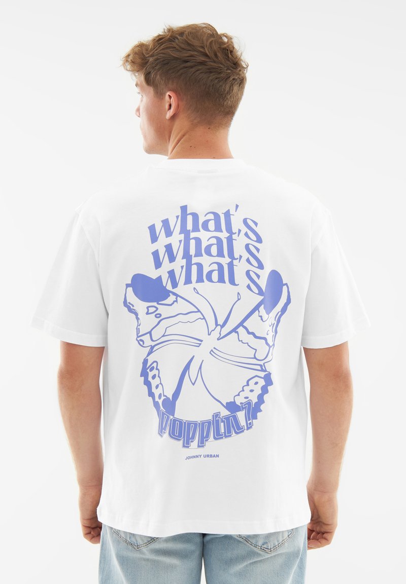 Biała bawełniana koszulka z dużą niebieską grafiką motyla oraz napisem na plecach, z luźnym krojem i krótkimi rękawami.