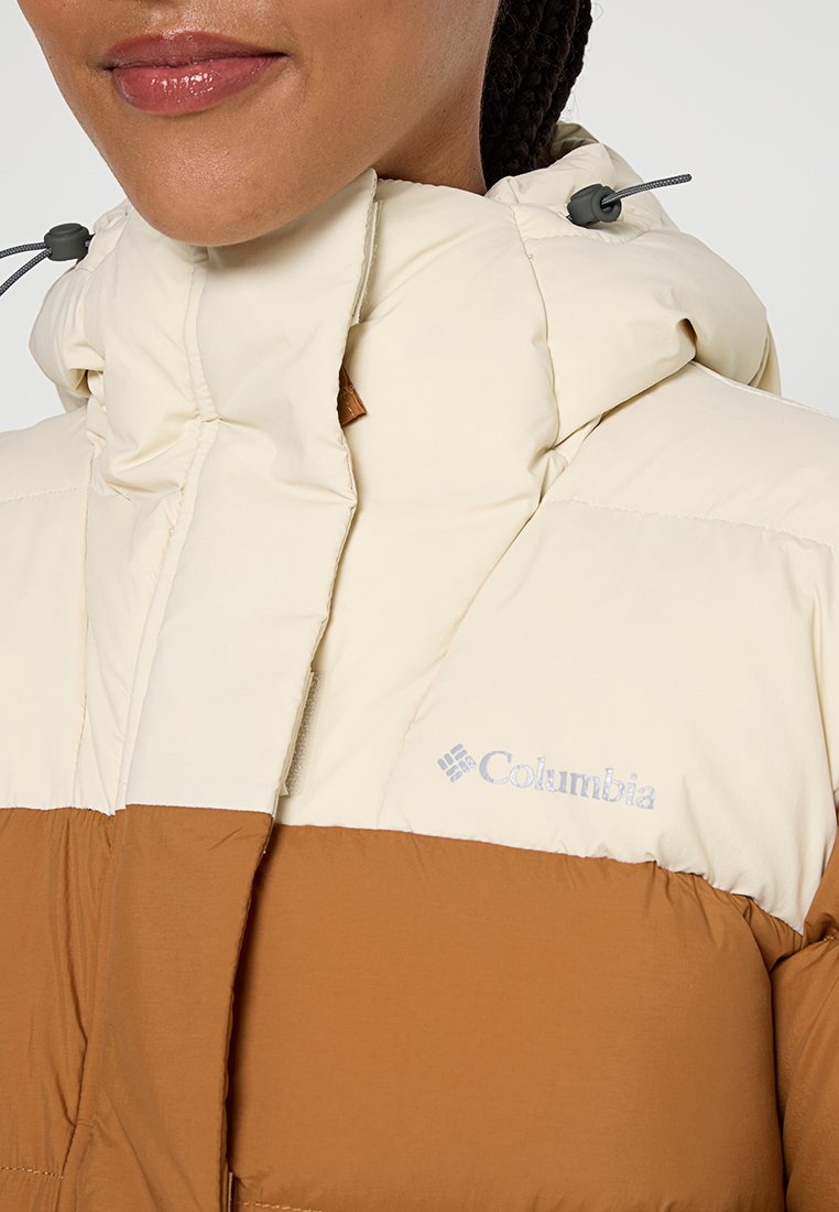 Kurtka puchowa z kremową górną częścią i brązową dolną częścią, z wysokim kołnierzem, kapturem ze sznurkiem i logo na przodzie.