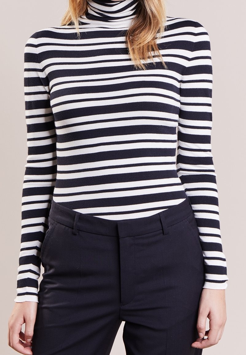 Maglietta a maniche lunghe con collo alto a righe blu navy e bianche, realizzata in un tessuto morbido ed elastico. Caratterizzata da un design aderente e una texture a costine.
