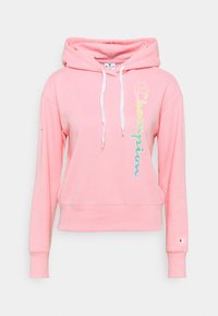 Rosa huvtröja med framfickor i känguru-stil, vita dragsnören och "Champion"-logotyp i flerfärgad skrift på vänster sida.