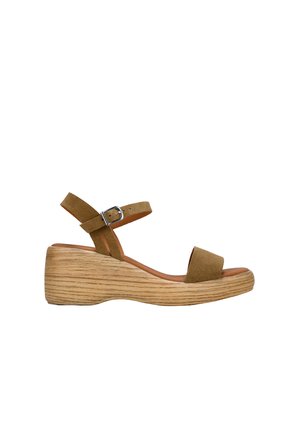 Sandalia cuña en ante marrón con dos tiras ajustables, plataforma de aspecto de madera y una textura suave. Cuenta con una hebilla para un ajuste seguro.
