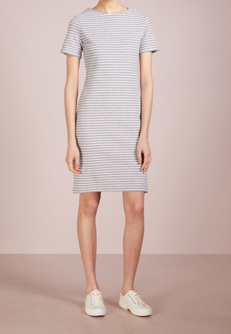 Robe à manches courtes à rayures grises et blanches, coupe ajustée, longueur genou, fabriquée en tissu léger, associée à des baskets blanches.