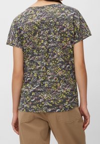 Blumenshirt mit kurzen Ärmeln auf dunklem Hintergrund, das Muster in Gelb, Pink und Weiß zeigt; Rundhalsausschnitt; gerafftes Detail auf der Rückseite.