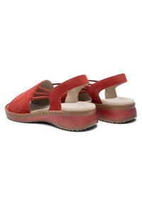 Red suede slingback sandals with cushioned beige insoles, thick textured rubber soles, and elastic side straps for secure fit.