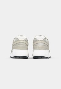 Gray running shoes with a suede and mesh upper, white midsole, black outsole, and prominent brand logo on the heel.