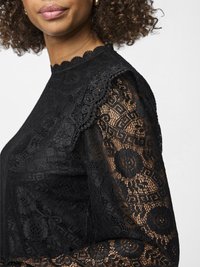 Svart blonde topp med bølget hals og blomsterdesign, gjennomsiktige lange ermer med intrikate blonde detaljer, tettsittende design.