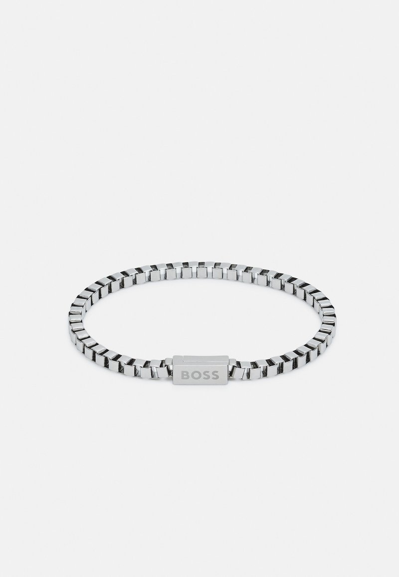 Metallarmbånd med firkantede lenker i sølvfarge, med en rektangulær lås merket med "BOSS." Glatt tekstur og moderne design.