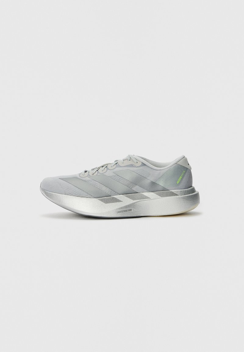 Shoe atlético leve em cinza, com um design elegante, apresentando um cabedal texturizado, três riscas diagonais e uma sola prateada reflexiva.