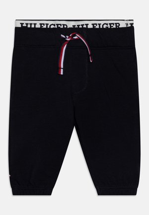 Schwarze Kleinkinderhose mit elastischen Bündchen, einem weißen Bund mit der Aufschrift „HILFIGER“ und einem rot-weiß-blauen Kordelzug vorne.