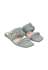 Sandali scivolati in denim blu con bordi sfilacciati, punta quadrata e una grande fibbia di gioielli come dettaglio distintivo. Tessuto morbido e suola piatta.