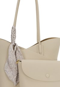 Beige læder tote taske med tekstureret overflade og et knyttet paisley-mønsteret tørklæde. Inklusiv en klaplomme med knaplukning.