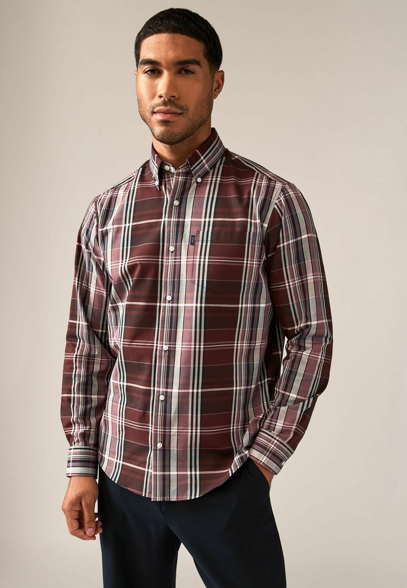 Camisa de botones de cuadros burdeos, con rayas blancas y azules. Mangas largas, puños abotonados y un bolsillo en el pecho. Tejido de mezcla de algodón.