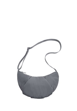 Sac d'épaule gris en forme de croissant, rembourré, avec une sangle ajustable et une fermeture éclair sur le dessus sur fond blanc.