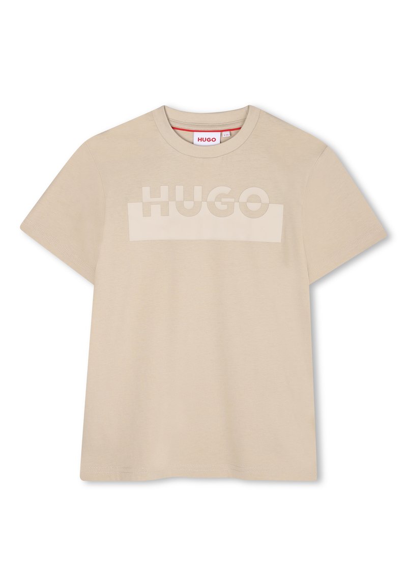T-shirt en coton beige avec un logo "HUGO" ton sur ton sur la poitrine, col rond et manches courtes. Texture lisse avec une coupe décontractée.
