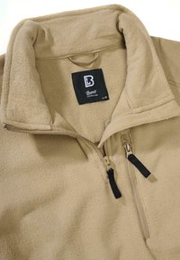 Beiger Fleece-Pullover mit halbem Reißverschluss, Stehkragen und schwarzen Reißverschlussakzenten. Verfügt über ein Markenlabel innen im Kragen. Größe M.