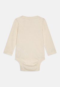 Bodysuit za bebe s dugim rukavima u mekanom kremastom pamuku, s okruglim izrezom, zatvaranjem na dugmad na dnu i naborima na leđima.
