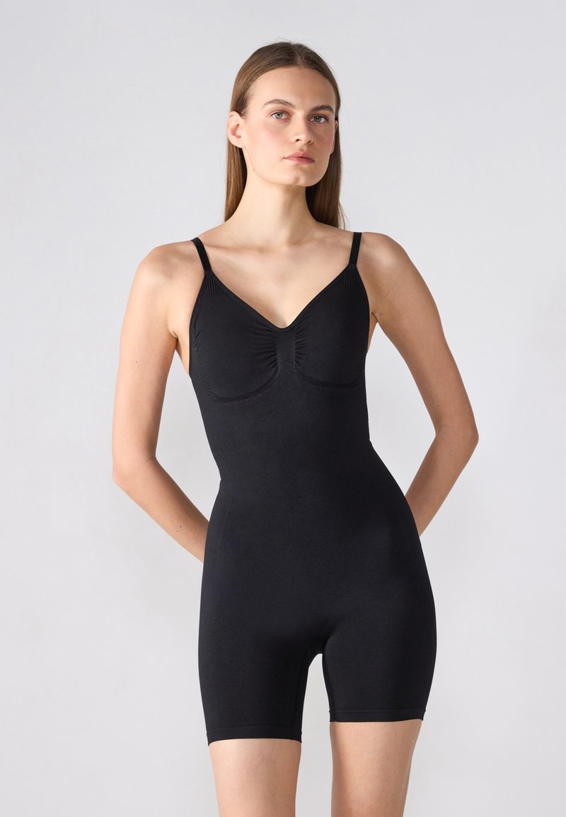 Body noir avec bretelles spaghetti réglables, décolleté en V et détail froncé à l'avant. Texture lisse avec une silhouette ajustée et une coupe short.