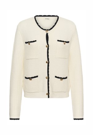 Bela teksturirana kardigan s črnim robom, zlatimi gumbi in dvema sprednjima žepoma. Ima okrogel ovratnik in sproščen kroj.