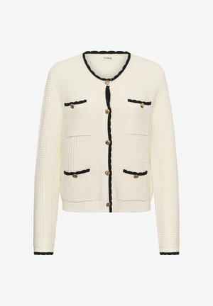 Valge tekstuuriga kardigan mustade äärte, kuldsete nööpide ja kahe esimeses taskuga. Omab ümmargust kaelust ja lõdvat istuvust.