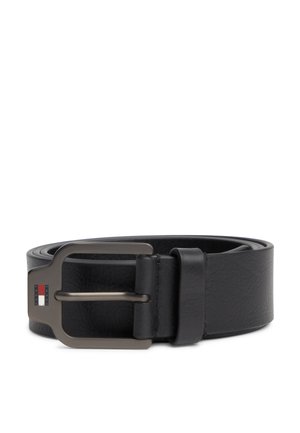 Ceinture en cuir noir enroulée avec une boucle en métal mat présentant un logo rectangulaire rouge, blanc et bleu sur le côté gauche de la boucle.