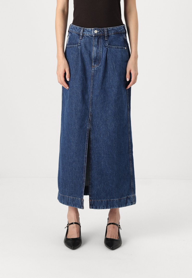 Denim maxi skirt in dark blue. Features a front slit, two side pockets, and a standard waistband with a button closure. Smooth texture.