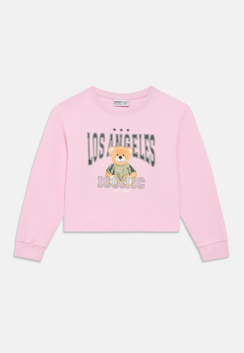 Ροζ ανοιχτόχρωμο κολαριστό φούτερ με μακριά μανίκια, με γραφικό αρκούδας και το κείμενο «LOS ANGELES ICONIC» σε σκούρο γκρι. Απαλό βαμβακερό υλικό.