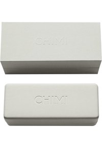 Vit rektangulär låda med präglad "CHIMI"-logotyp; locket är platt, lådan är strukturerad; den kompakta designen är lämplig för glasögon eller tillbehör.