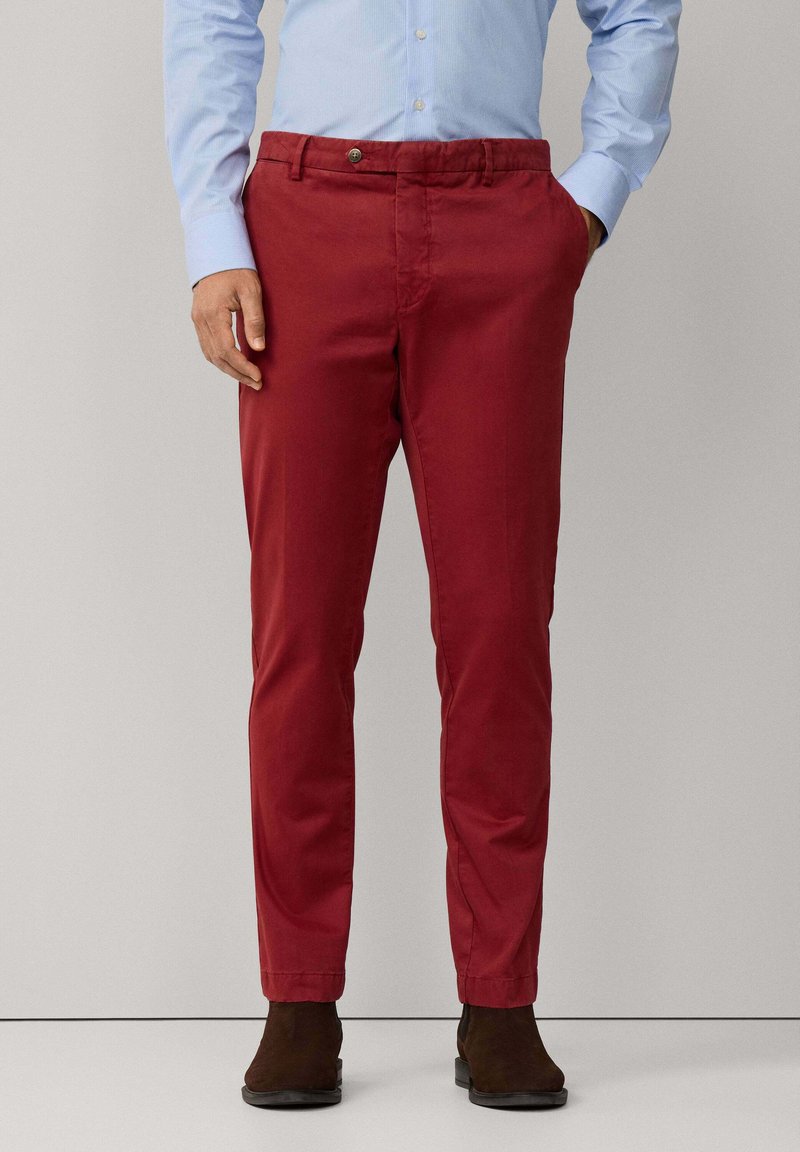 Rote Baumwoll-Chinos mit geradem Schnitt, Reißverschluss und Knopfverschluss. Seiten Taschen, Gürtelschlaufen und eine glatte, leicht strukturierte Oberfläche.