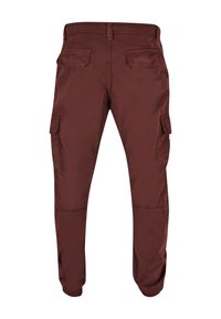 Burgunderrote Cargo-Hosen mit schmalem Schnitt, ausgestattet mit Seitentaschen, elastischen Bündchen und einer glatten Oberfläche. Entworfen für Komfort und Funktionalität.