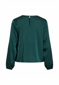 Blouse en satin vert foncé à manches longues, avec une petite ouverture en forme de goutte et une fermeture par bouton dans le haut du dos.