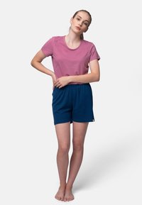 Roze katoenen t-shirt gecombineerd met donkerblauwe shorts met elastische tailleband; beide hebben een ontspannen pasvorm en een minimalistisch ontwerp. Geen patronen of hardware.